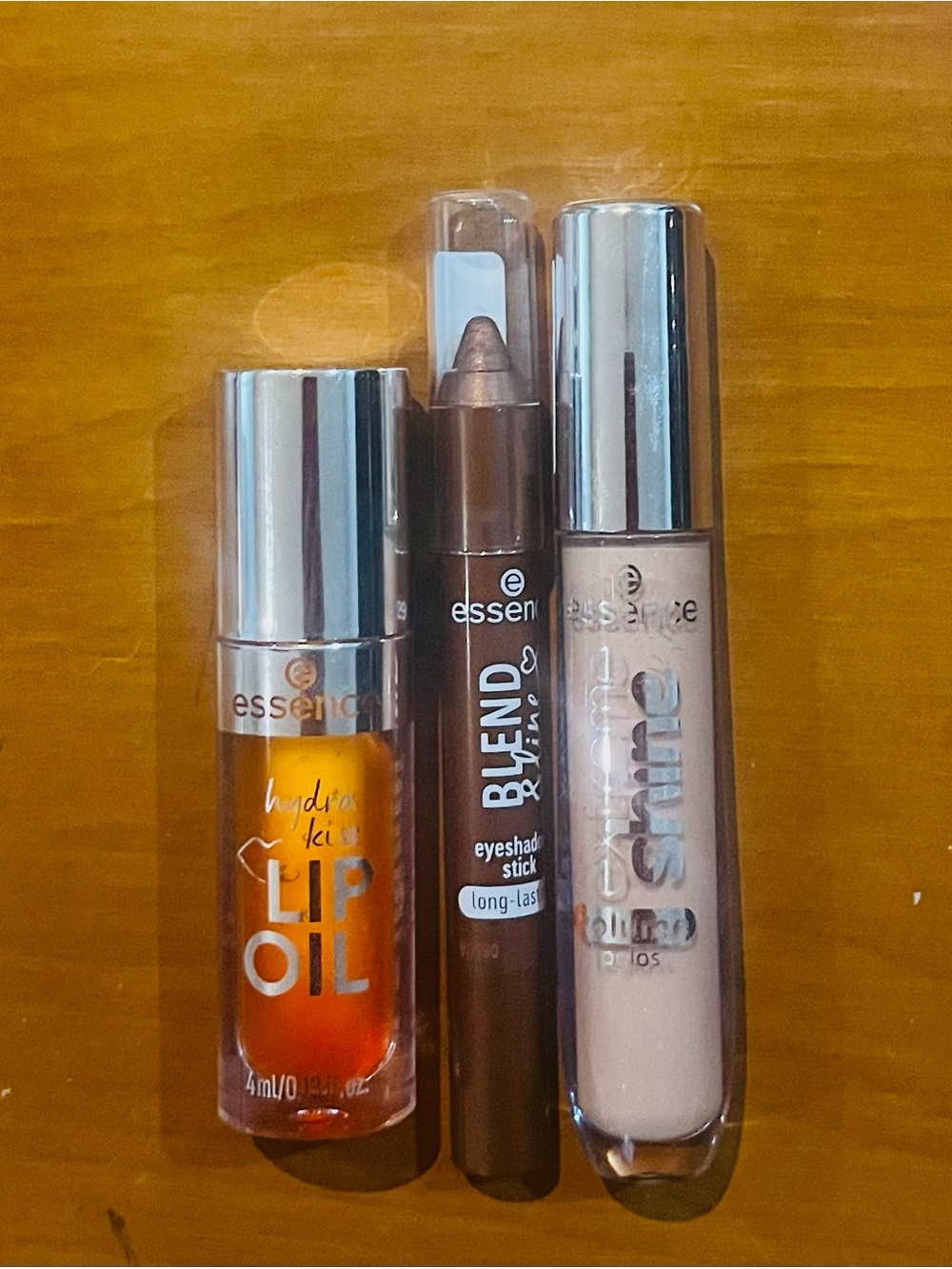 Essence Orange Lip Oil, Dark Brown Eyeshadow Stick, and Nude Lip Gloss-3 Set